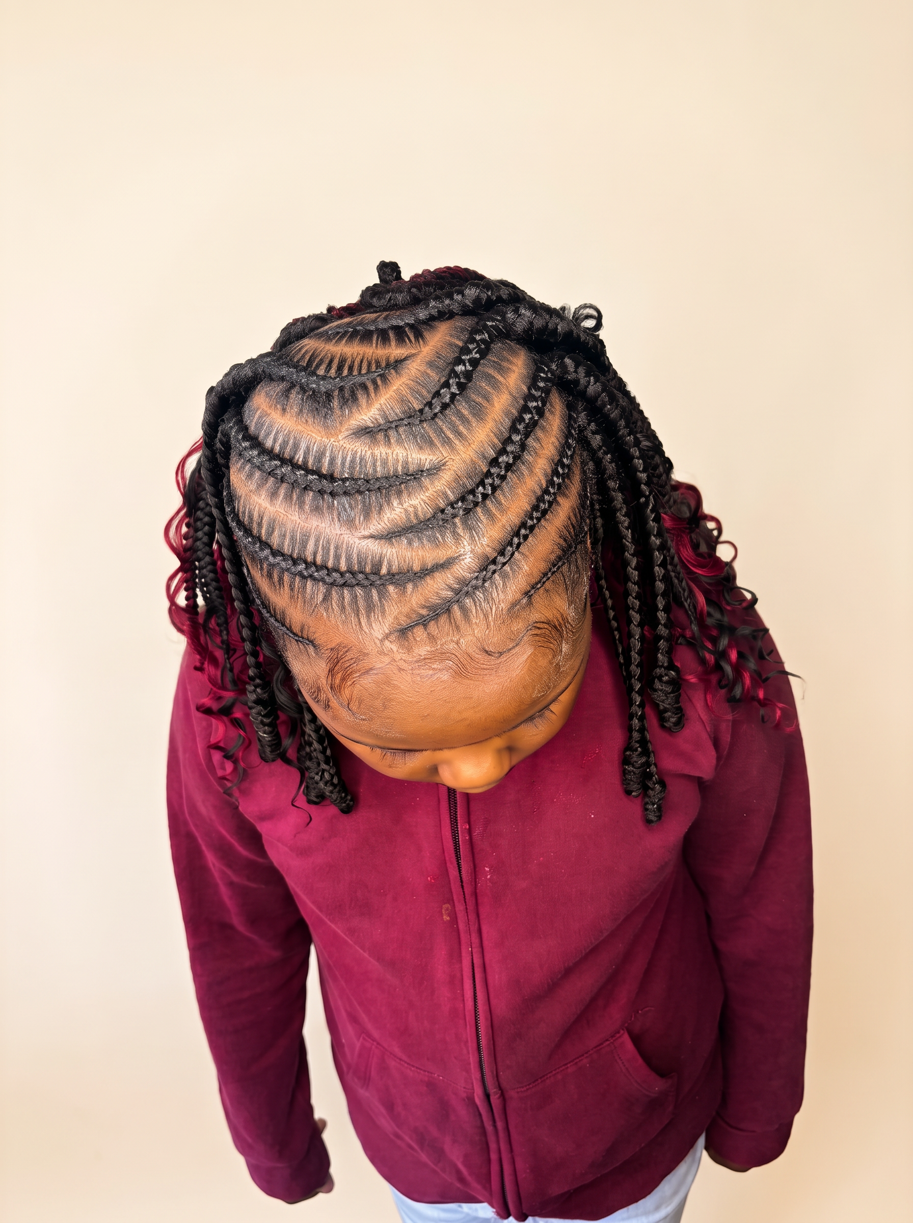 Child with neat cornrows and curled ends